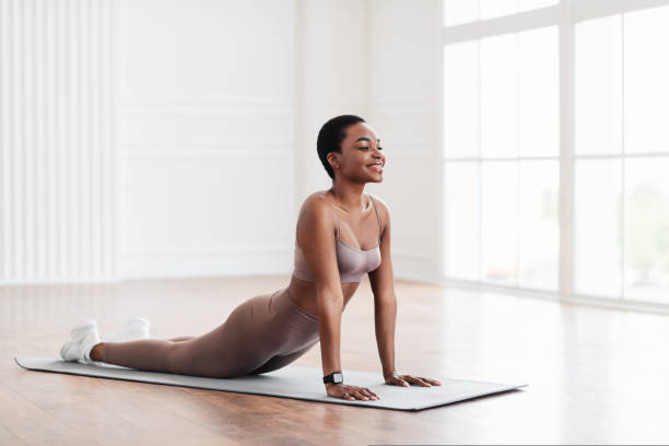 istock Young black woman stretching back on mat in cobra pose 1434119439