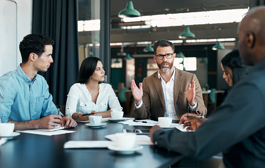 Business people, meeting and planning in team conference for marketing strategy, ideas and discussion at the office. Group of diverse corporate employee workers in teamwork conversation for sales