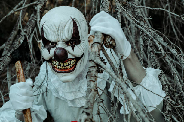 istock evil clown with an axe in the woods at dusk 1434129110