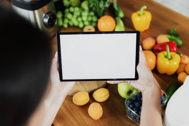 istock Female hands using, holding tablet at kitchen. Food delivery, mobile dieting app 1434129140