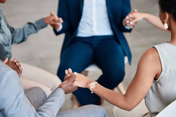 istock Support, trust and collaboration with a group of business people holding hands while sitting in circle for a team building workshop. Pray, motivation and diversity in a corporate office or workplace 1434130564