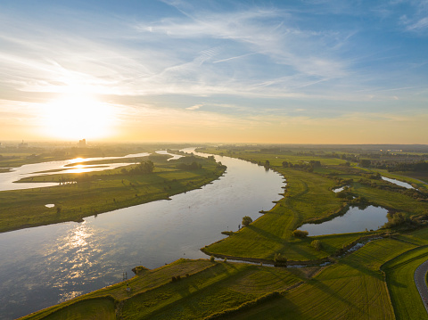 Sunrise over the river IJssel in the IJsseldelta during fall. Panoramic landscape with the winding river.