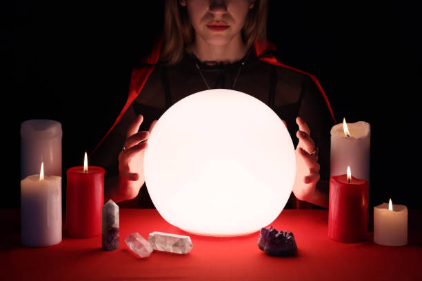 istock Soothsayer using glowing crystal ball to predict future  at table in darkness, closeup. Fortune telling 1434132380