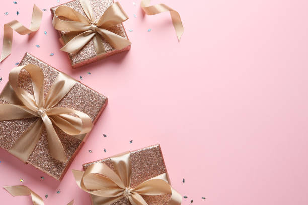 istock Three gift boxes and confetti on pink background, flat lay. Space for text 1434132493