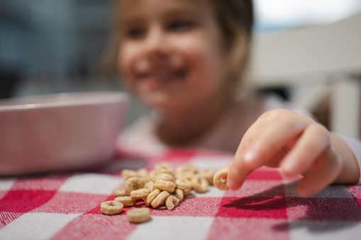 Caucasian toddler girl, having cereal for breakfast