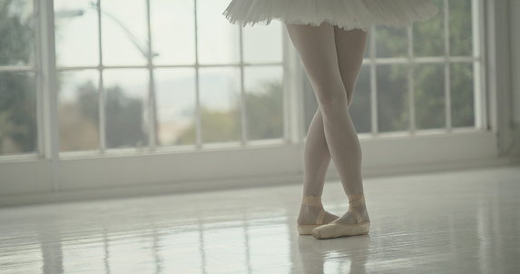 Dance, art and ballerina shoes and legs practicing for theater performance, concert or recital. Elegant, classical and closeup of ballet dancer dancing in the studio of her artistic academy or school