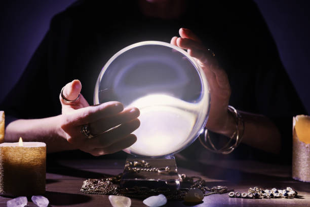 istock Soothsayer using crystal ball to predict future at table in darkness, closeup. Fortune telling 1434132768