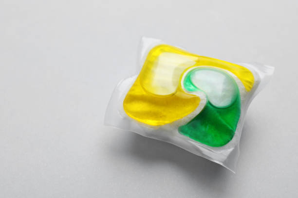 istock Dishwasher detergent pod on light grey background, closeup. Space for text 1434132925