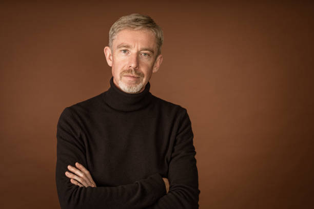 istock Studio portrait of white 50 year old man with beard on brown background 1434133076