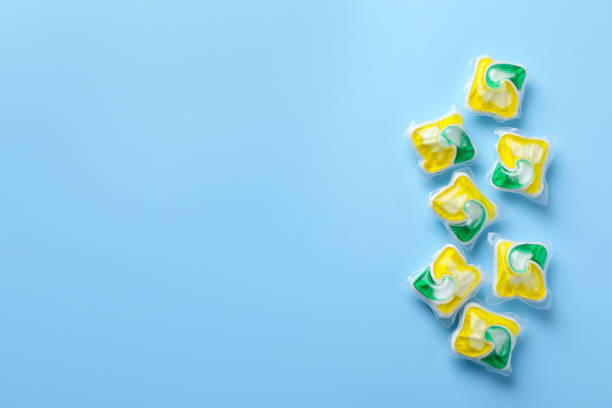 istock Many dishwasher detergent pods on light blue background, flat lay. Space for text 1434133096