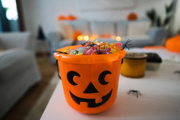 Bucket in a pumpkin shape, full with candy Bucket in a pumpkin shape, full with candy after Trick or Treat halloween candy stock pictures, royalty-free photos & images