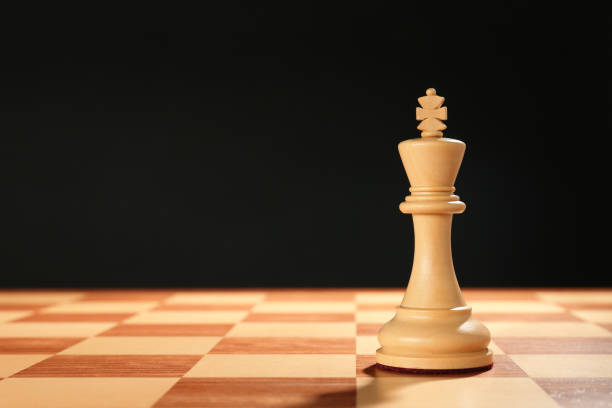 istock Wooden king on chessboard against dark background, space for text 1434133332