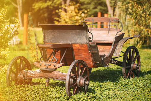 Garden Decoration Concept. Decorative Yard Wagon On Summer Lawn. Bright Sunny Day. Gardening And Housekeeping. Vintage Cart On Summer Sunny Day. Garden Wagon. Trolley. Old Wooden Cart.