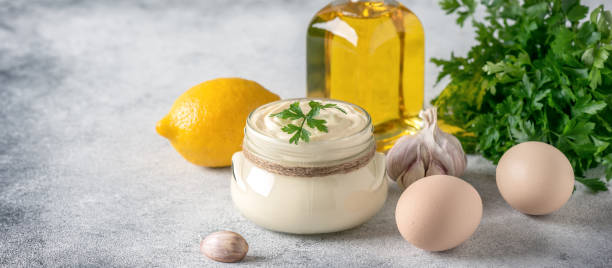 istock Aioli sauce with ingredients on a light gray grunge background. Side view, selective focus, copy space. Banner 1434136915