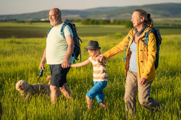 istock Two senior adults and a boy striding across a large grassy field 1434138076