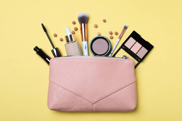 istock Cosmetic bag with makeup products and accessories on yellow background, flat lay 1434138321