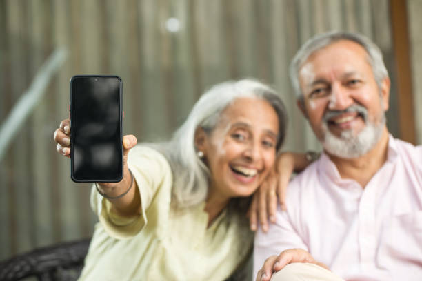 istock Cheerful old couple showing mobile phone screen 1434138946