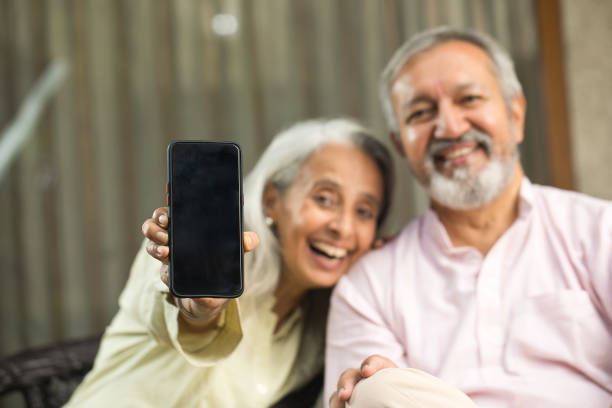 istock Cheerful old couple showing mobile phone screen 1434139042