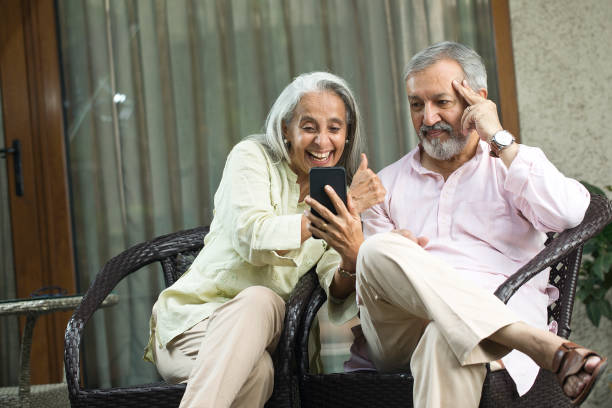 istock Happy senior couple using mobile phone at home 1434139252