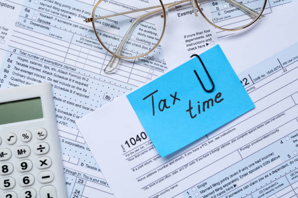 istock Reminder note with words Tax Time, glasses and calculator on documents, flat lay 1434139449