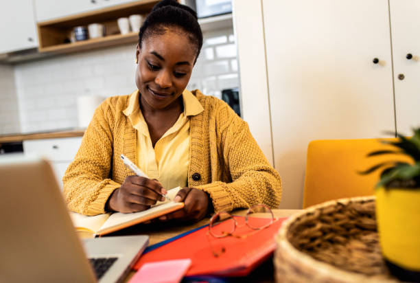 istock Young African American female student studying at home using laptop. 1434139554