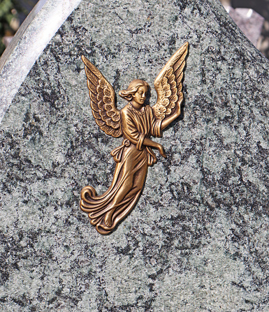 Angel figurine on the tombstone in the public cemetery