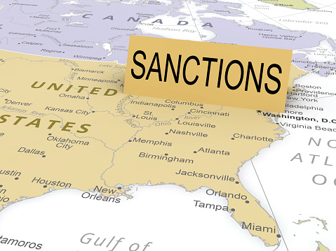 Sanctions paper card on map of USA. As background used CIA Map that are in the public domain https://www.cia.gov/the-world-factbook/maps/world-regional/