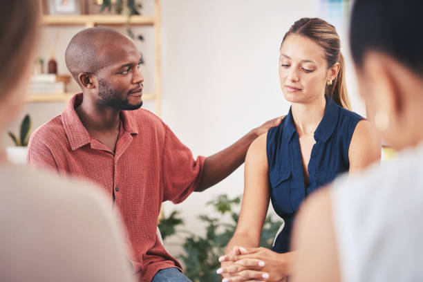 istock Support, comfort and console member in a therapy team meeting or gathering. Communication or caring employees showing empathy to sad woman with mental health problem in work group therapy session 1434146149