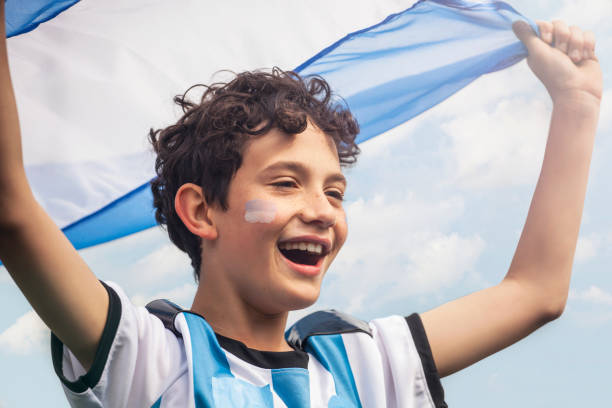 istock Young Argentine boy waving flag while cheering for national team outside stadium 1434146522