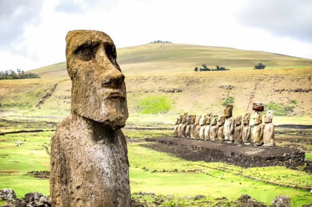 close up of moai ha'ere ki haho " the traveling statue " at the entrance of ahu tongariki spot area on world famous easter island in chile - travel wanderlust concept - vivid filter on cloudy day - moai statue statue ancient past imagens e fotografias de stock