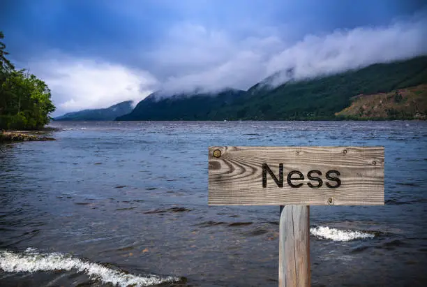 Loch Ness with wooden sign photomount in Scotland Highlands UK famous for the Nessie monster sightings.