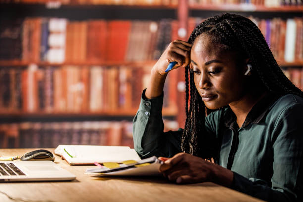 istock Woman studying in a library, sitting at desk 1434151567
