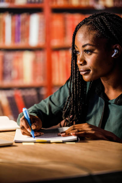 istock Concentrated student listening to online course, highlights notes in a notebook 1434151709