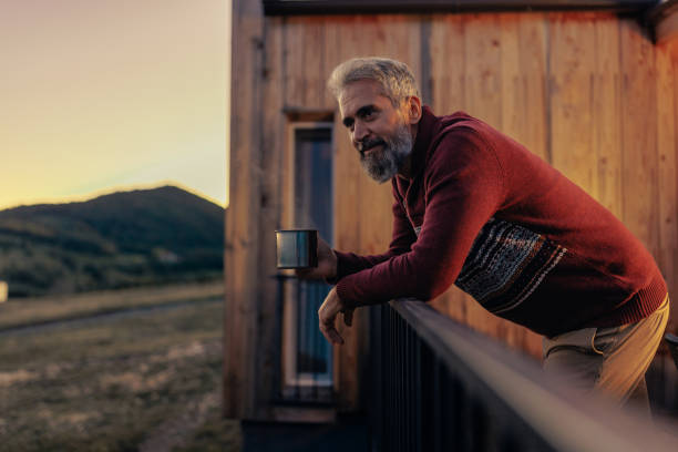 istock Senior man drinking tea at mountain cabin. 1434152536