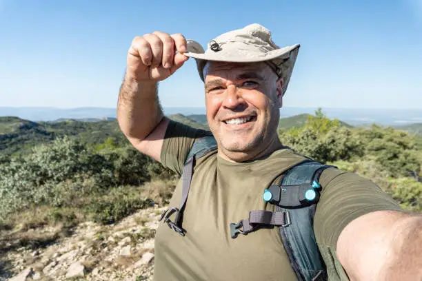 Photo of happy man hiker selfie hat landscape