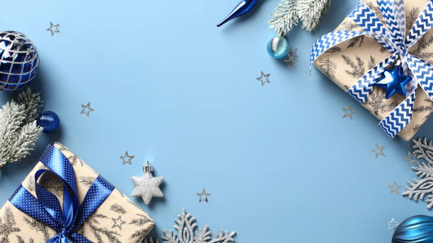 istock Elegant Christmas flat lay composition. Top view Xmas gift boxes, fir branches, blue baubles and decorations on pastel blue background. Modern Christmas card template, New Year banner design. 1434154640