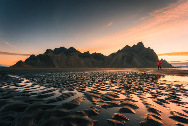 Sunrise over Vestrahorn mountain with rippled black sand beach in summer on Stokksnes peninsula at Iceland Stunning view of sunrise over Vestrahorn mountain with rippled black sand beach in summer on Stokksnes peninsula at Iceland irish travellers photos stock pictures, royalty-free photos & images