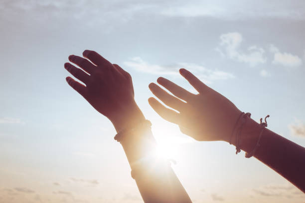 istock Woman hands against blue sky and sun 1434157082