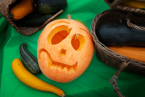 Pumpkin for Halloween on the background of autumn vegetables and fruits.