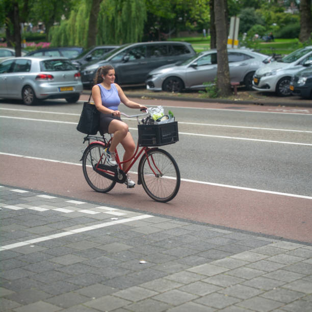 Amsterdam, North Holland, the Netherlands, 11th of July 2021, Young girl  on a bicycle riding a bike on bicycle path passing Rijksmuseum