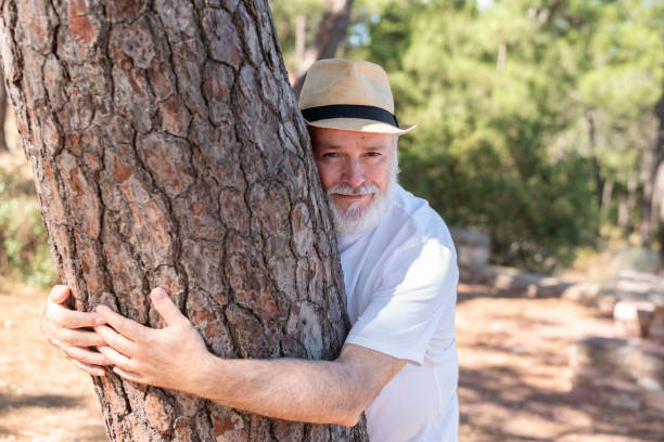 istock close-up of an elderly retired man hugging a tree looking at the camera 1434162598