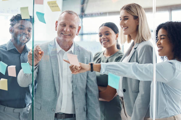 istock Business people planning on sticky note in meeting, post it paper for creative advertising idea and team collaboration for marketing project. Teamwork for global company strategy on glass in office 1434165352