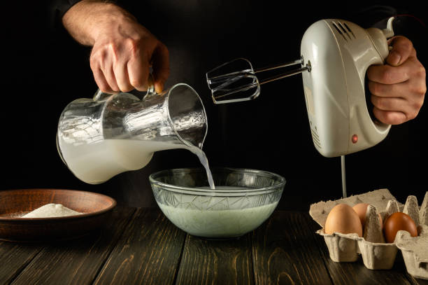 istock The chef prepares a delicious dinner with milk and eggs in the kitchen using an electric hand mixer. The cook pours the poloko into a deep plate. Delicious recipe menu for hotel. 1434165402