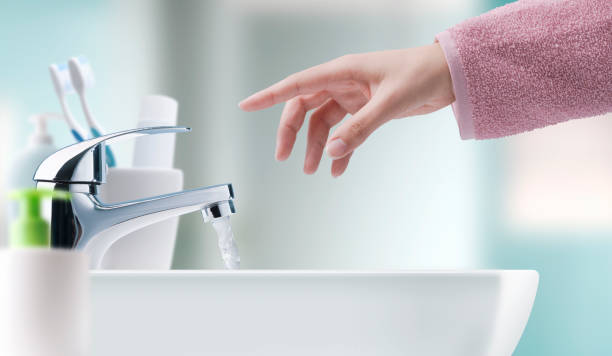 Woman washing hands in the bathroom