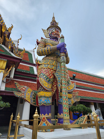 The giant guarding the temple's door at Wat Phra Kaeo 12th, named, askanmara, seven-faced purple body with two hands, standing holding a mace, Bangkok, Thailand