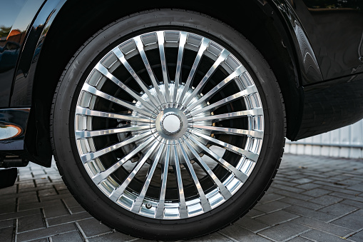 Aluminium rim of luxury black suv car wheel close up photo