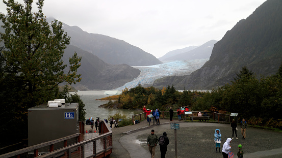 Juneau, AK - Sep 25, 2022: Tourists visiting the Mendenhall glacier that disappears more every day.