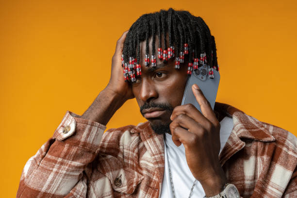 istock Young african man talking on smartphone stressed with hand on head on yellow background 1434176091