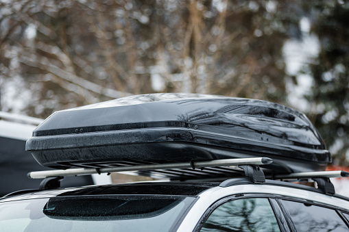 Roof rack with cargo box on car roof in winter.