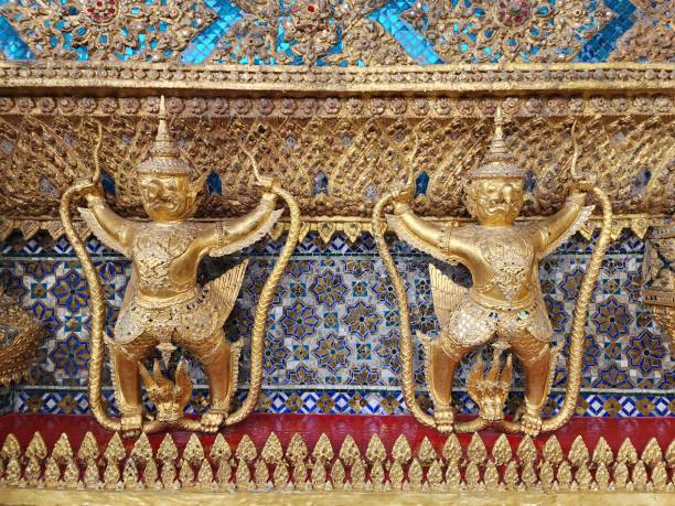 garuda captura a estátua de naga forrada ao redor da base externa ao redor do ubosot de wat phra kaew - bangkok thailand demon majestic - fotografias e filmes do acervo